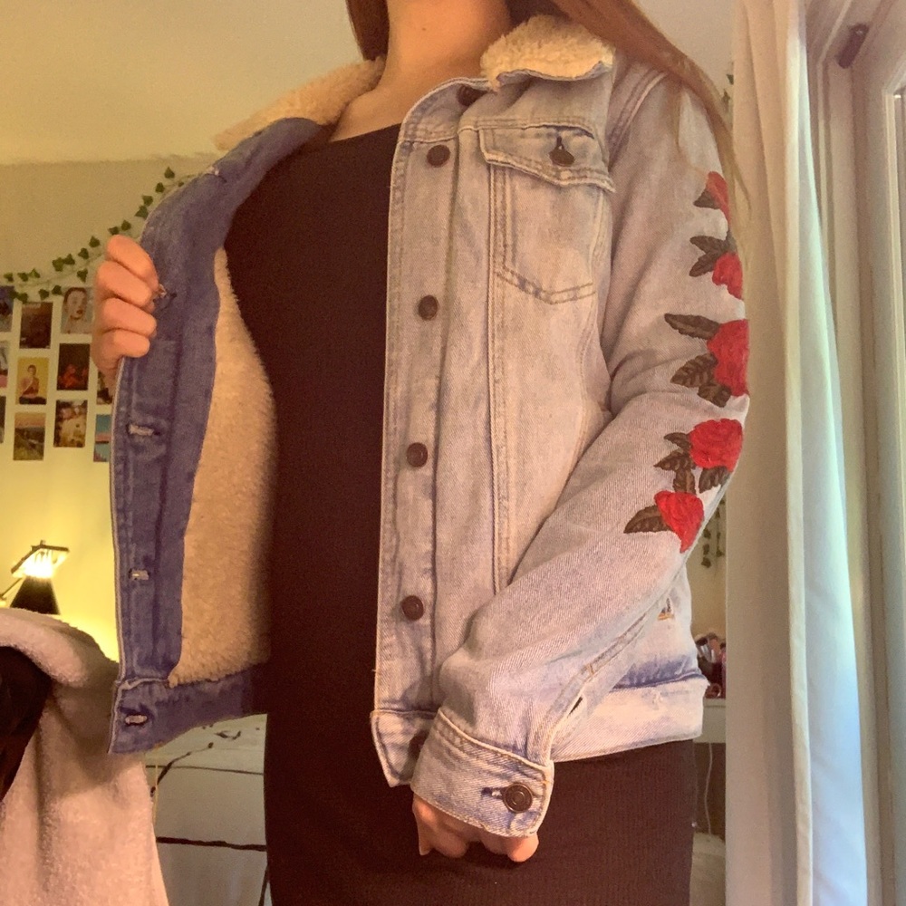 jean jacket with floral pattern on the sleeves.